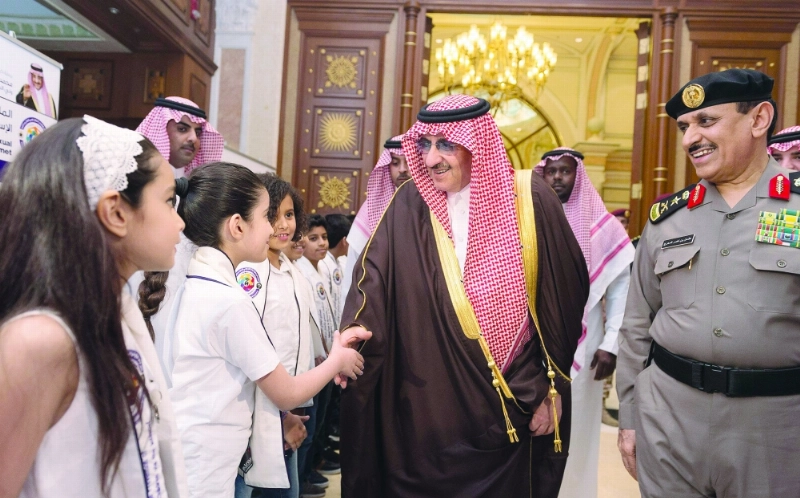 الأمير محمد بن نايف مصافحا عددا من الأطفال الحاضرين للملتقى (واس)