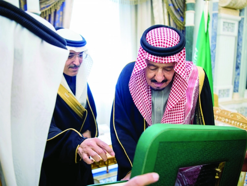 الملك سلمان لدى تسلمه الرقم الأول من فئات الإصدار السادس للعملة