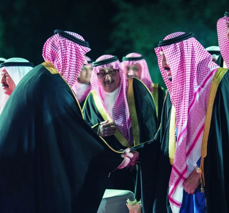 الملك سلمان مصافحا الشاعر مشعل الحارثي بعد إلقاء قصيدته في البحرين (بندر الجلعود)