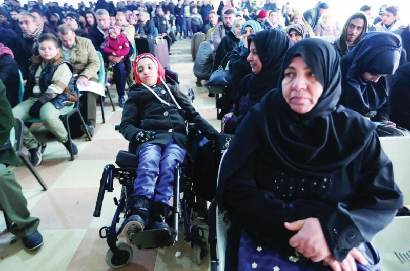 فلسطينيون ينتظرون في منفذ رفح بغزة للعبور لمصر أمس (رويترز)
