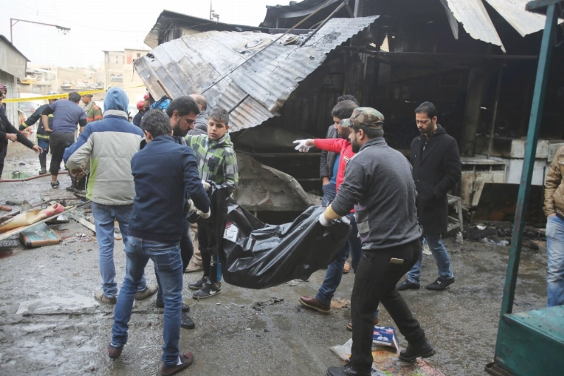 عراقيون يحملون جثمان ضحية التفجير ببغداد (أ ب)