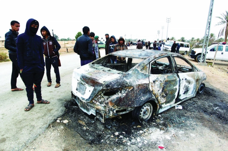 الشرطة العراقية تحيط بسيارة مدمرة قرب النجف أمس (أ ف ب)
