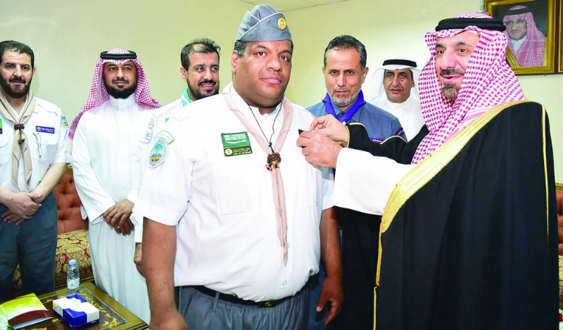 جلوي بن عبدالعزيز مقلدا أحد أفراد الكشافة نوط الحج (واس)