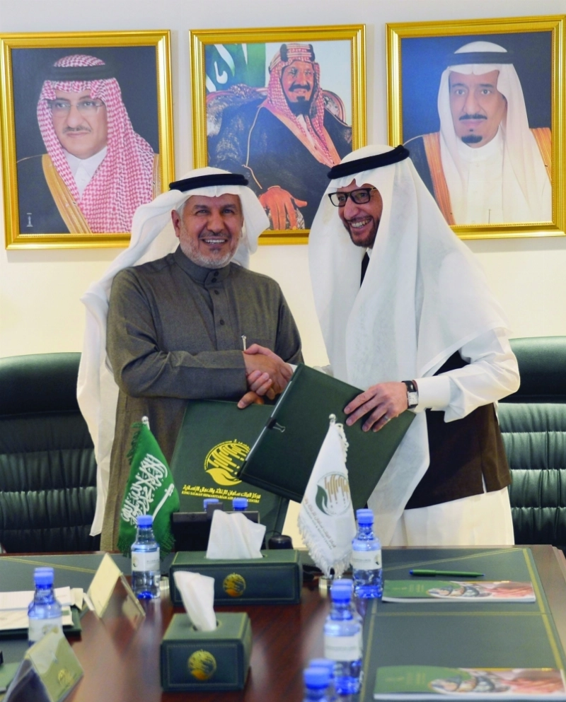 الربيعة يصافح العثيمين عقب توقيع الاتفاقية (واس)