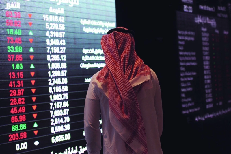 مستثمر يطالع شاشات تداول الأسهم السعودية (مكة)