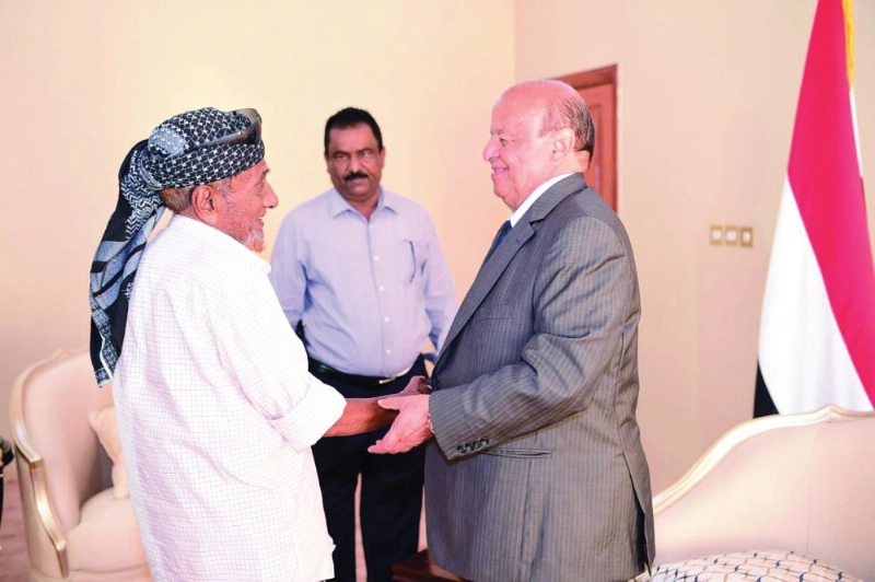 هادي يصافح مواطنا يمنيا فقد 4 أبناء في الحرب ضد الميليشيات (سبأ نت)