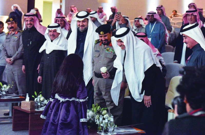 العيسى يمنح طفلة وردة خلال تدشين المنتدى (واس)
