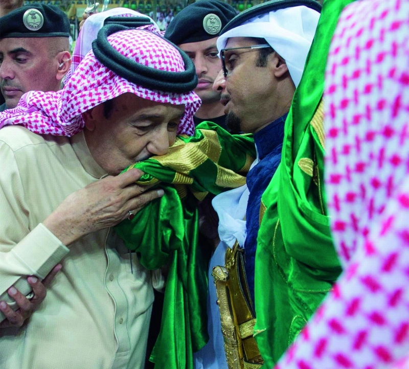 الملك سلمان مقبلا العلم خلال العرضة السعودية في جنادرية 30 (واس)