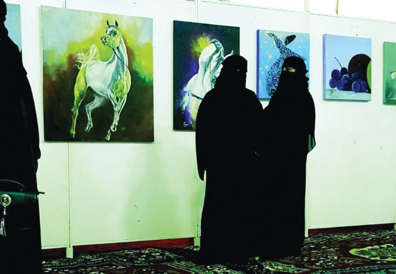 زائرتان تطالعان لوحات المعرض (مكة)