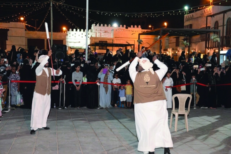 متسوقون يشاهدون لعبة المزمار الشعبية (مكة)
