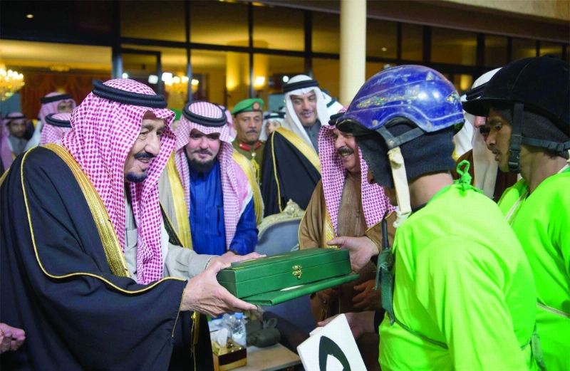 الملك سلمان خلال تسليم أحد الفائزين جائزته
