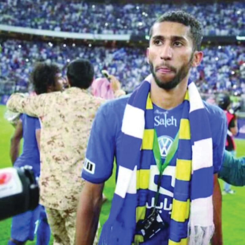سلمان الفرج مرتديا شال النصر بجانب شعار الهلال (مكة)