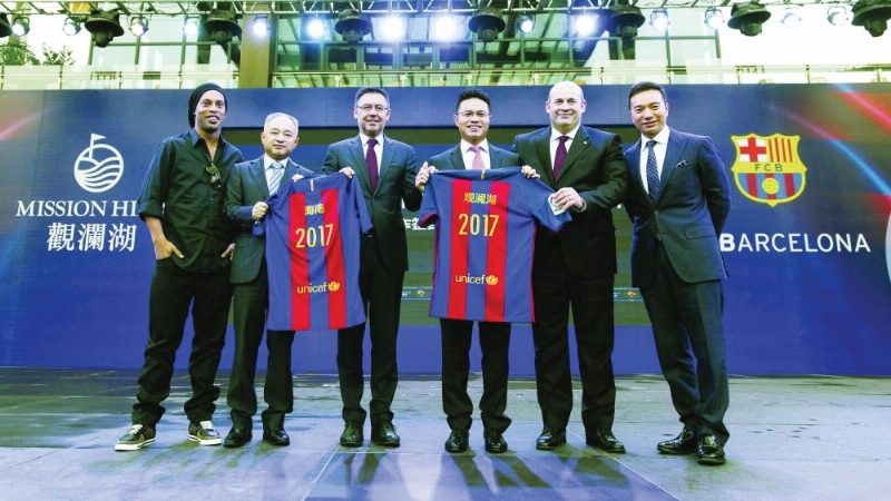 مسؤولو برشلونة والمجموعة الصينية بعد توقيع العقد (إ ب أ)