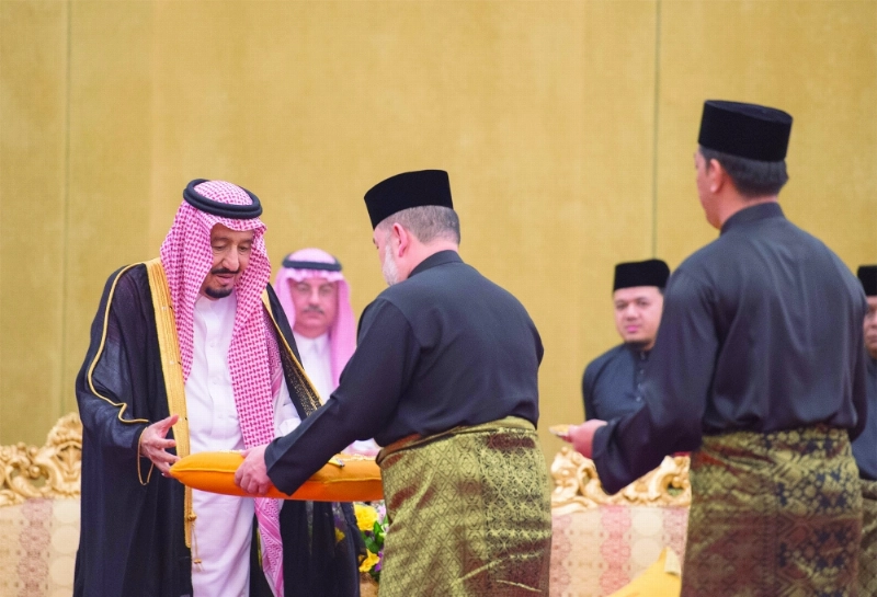 الملك سلمان خلال تسلمه وسام التاج من ملك ماليزيا