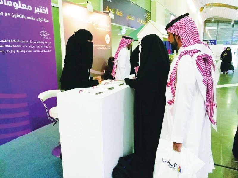 مشرفة ركن جزيل تشرح فكرة المبادرة لزوار معرض الكتاب (مكة)