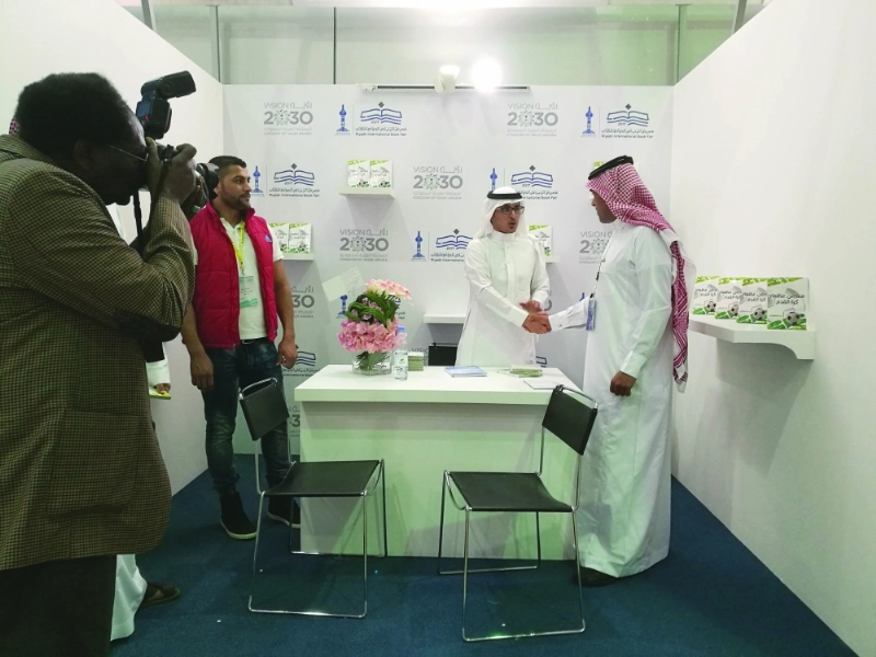 بندر المشرافي في المنصة مستقبلا المشرف العام على معرض الكتاب عبدالرحمن العاصم (مكة)
