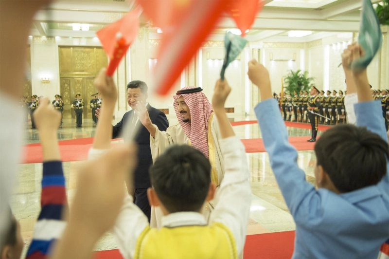 الملك سلمان محييا مجموعة من الأطفال خلال مراسم استقباله (بندر الجلعود)