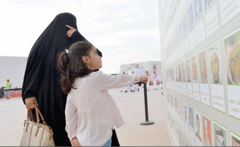 طفلة ووالدتها أمام جدارية الشرف (واس)