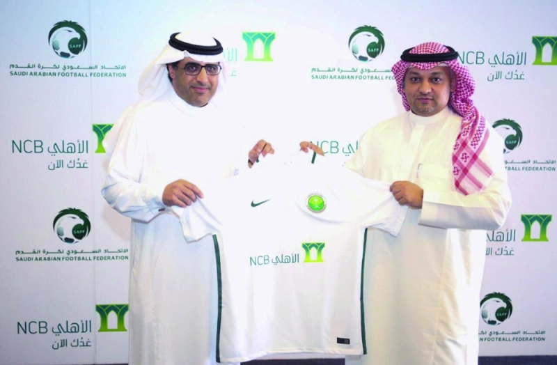 قميص الأخضر بعد التوقيع مع البنك أمس (مكة)