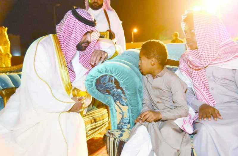 محمد بن عبدالعزيز لدى زيارته أسرة الشهيد حدادي (واس)