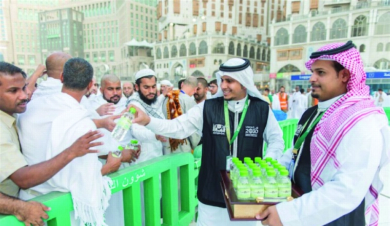 منسوبان من الرئاسة يوزعان المياه على الزوار (مكة)