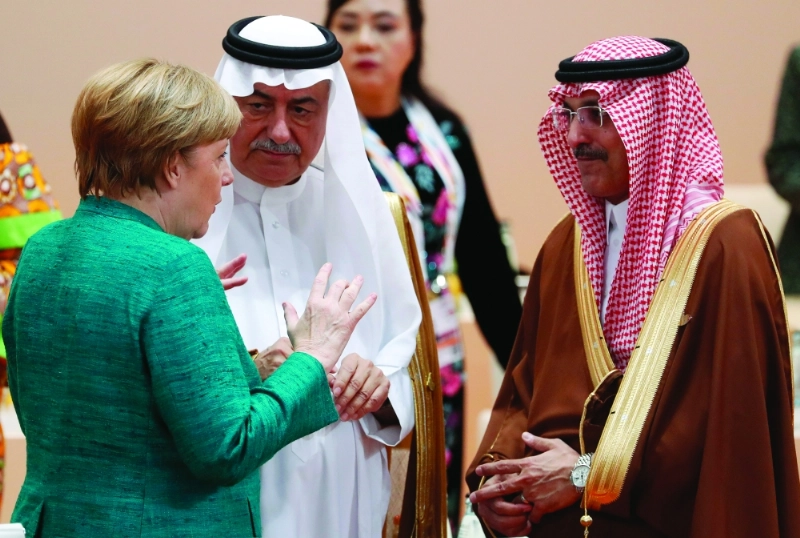 العساف في حديث مع المستشارة ميركل بحضور وزير المالية محمد الجدعان (إ ب أ)