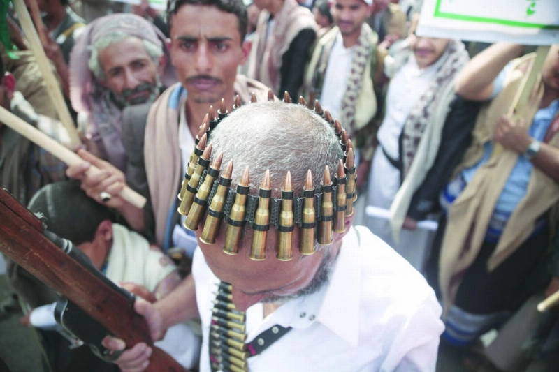 متمرد حوثي يضع حزاما من الذخيرة على رأسه (رويترز)