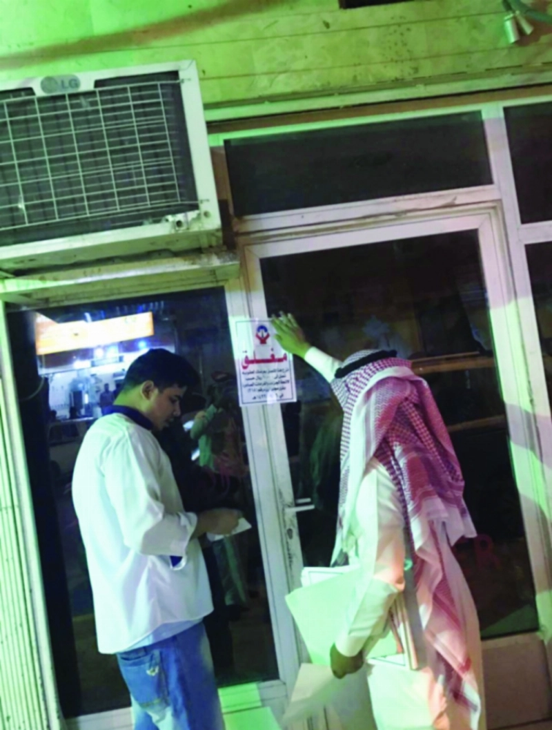 موظف البلدية يغلق أحد المحلات المخالفة (مكة)