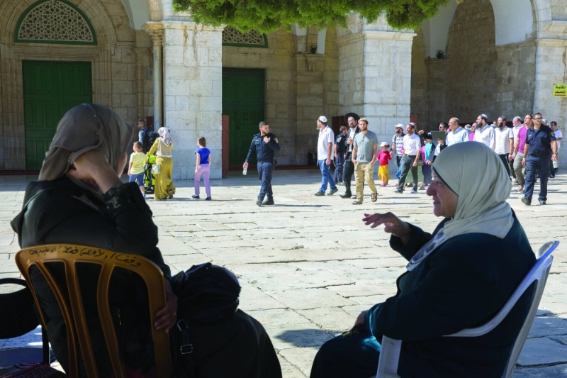 فلسطينيتان بالأقصى فيما يحرس جنود الاحتلال مقتحمين يهودا (إ ب أ)