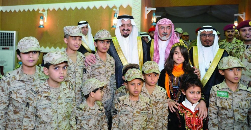 فيصل بن خالد يتوسط أبناء شهداء الواجب خلال رعايته حفل التخريج (واس)