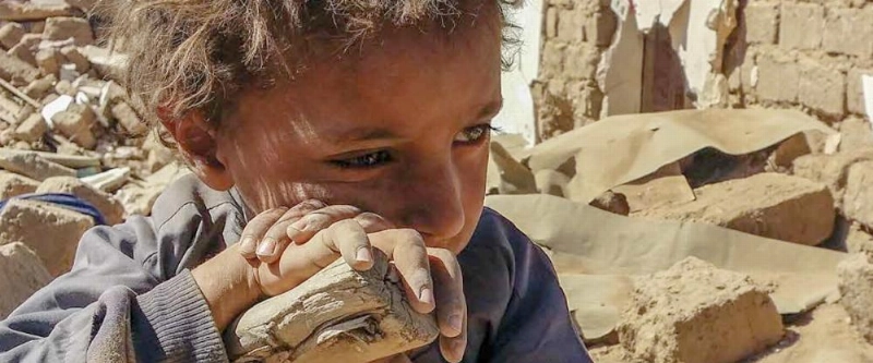 طفل ينظر إلى بقايا منزل مدمر (منظمة الأمم المتحدة للطفولة)
