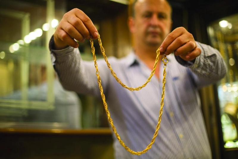 A gold vendor puts a piece of gold jewellery up for sale in a market in Gaza City, 27 August 2017. Photo: Mahmoud Issa/Quds Net News via ZUMA Wire/dpa