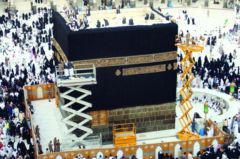 منسوبو رئاسة الحرمين ومجمع الملك عبدالعزيز للكسوة يستبدلون ثوب الكعبة أمس (واس)