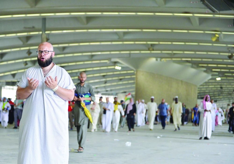 حاج يبتهل بالدعاء على جسر الجمرات أمس (واس)