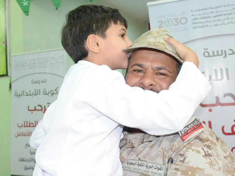 طفل يقبل رأس أحد الضباط بالحد الجنوبي أمس (واس)