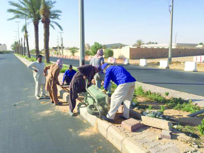 عمال يعيدون تأهيل أحد الشوارع بالجوف (مكة)