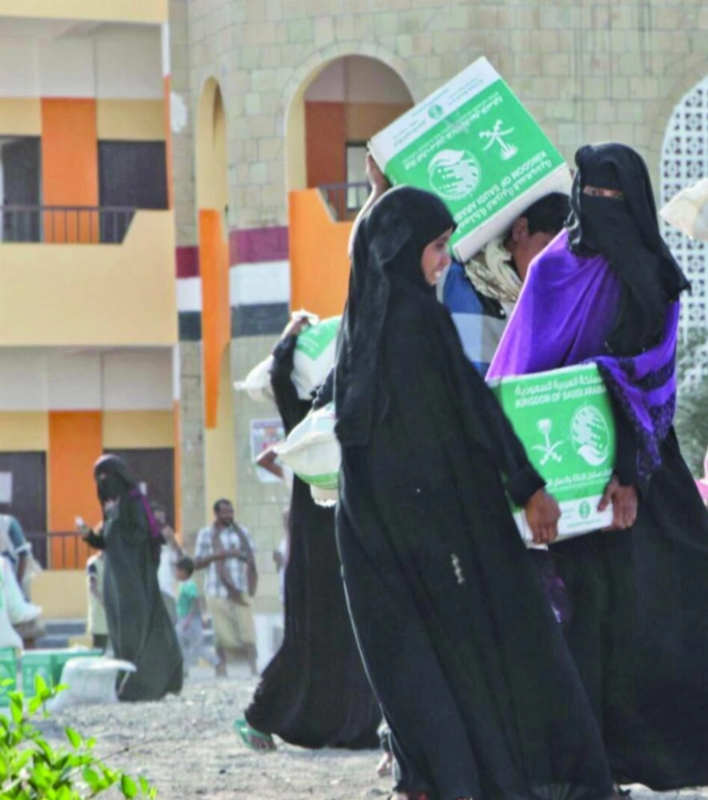 يمنيات يحملن سلالا غذائية من مركز الملك سلمان