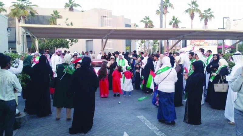 طلبة يحملون أعلام الإمارات والسعودية خلال الاحتفالية (وام)