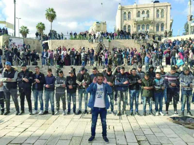 فلسطينيون يؤدون صلاة العصر أمس أمام باب العامود في القدس (تويتر)