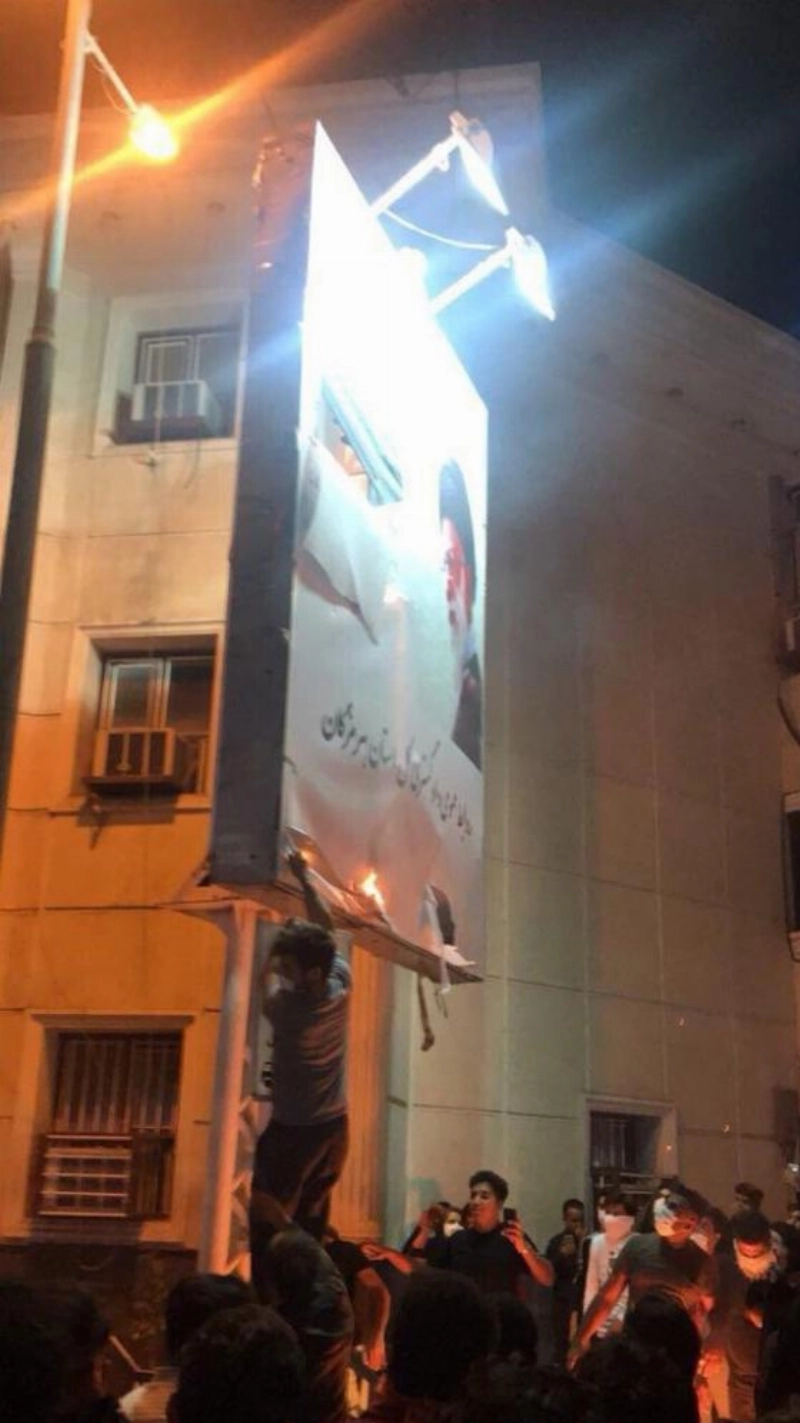 متظاهرون يمزقون صورة خامنئي أمس (تويتر)