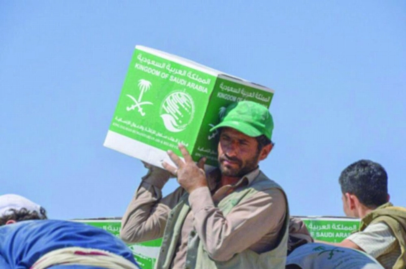 يمنيون يفرغون مساعدات إغاثية من الطائرة السعودية (واس)