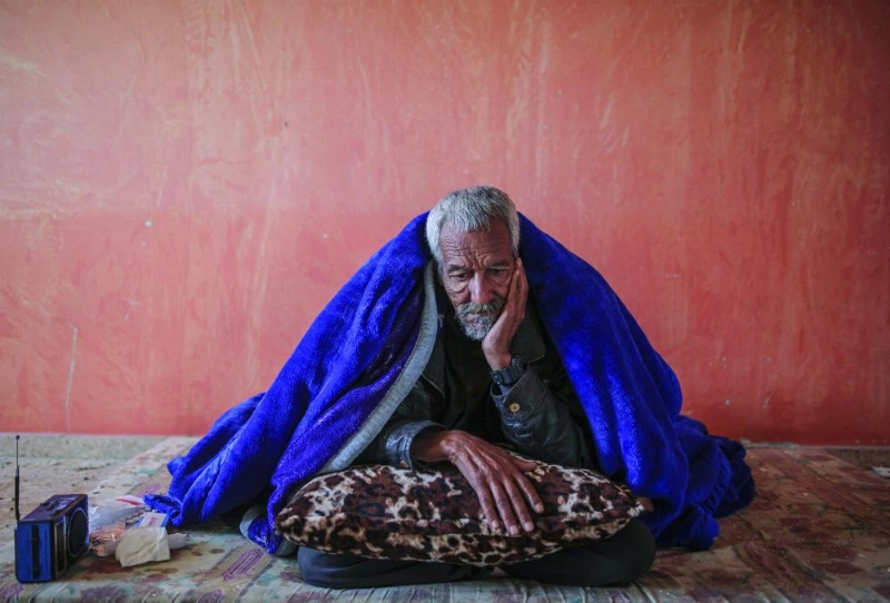 مسن فلسطيني داخل مسكنه الذي تعرض لأضرار من غارة إسرائيلية على غزة (د ب أ)