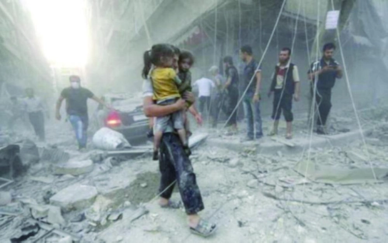 سوري يحمل طفلتين عقب غارة لطيران النظام في الغوطة (تويتر)