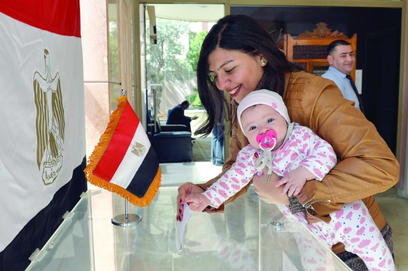 سيدة برفقة طفلتها تدلي بصوتها في السفارة المصرية ببيروت (إ ب أ)