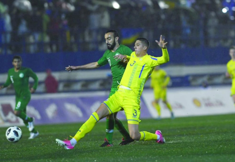 محمد السهلاوي يبحث عن الكرة أمام مدافع أوكراني (الاتحاد السعودي)