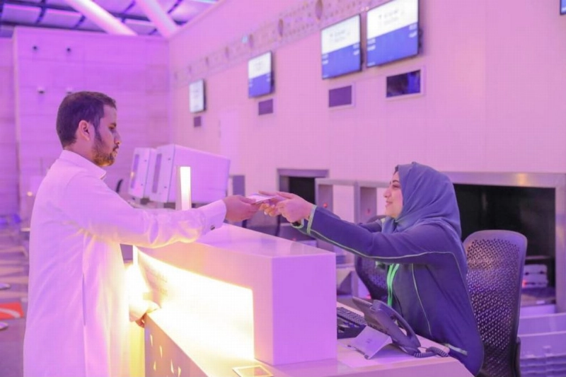 موظفة بالمطار تنهي إجراءات أحد المسافرين (مكة)