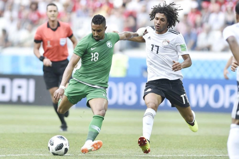 سالم الدوسري محاولا التسديد وسط مضايقة محمد النني (الاتحاد السعودي)