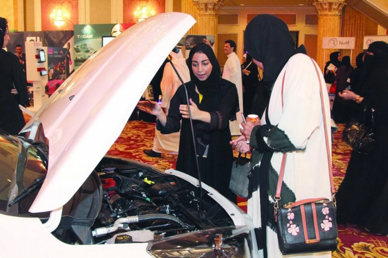 سيدة تشرح لزائرة محتويات المركبات خلال المعرض (مكة)