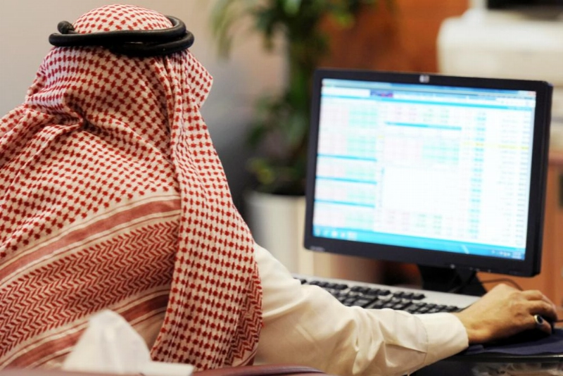 مستثمر يتابع شاشة الأسهم السعودية (مكة)