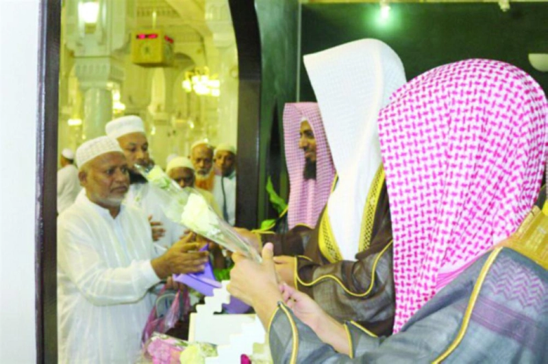 من تقديم الورود إلى زوار المسجد الحرام (رئاسة الحرمين)
